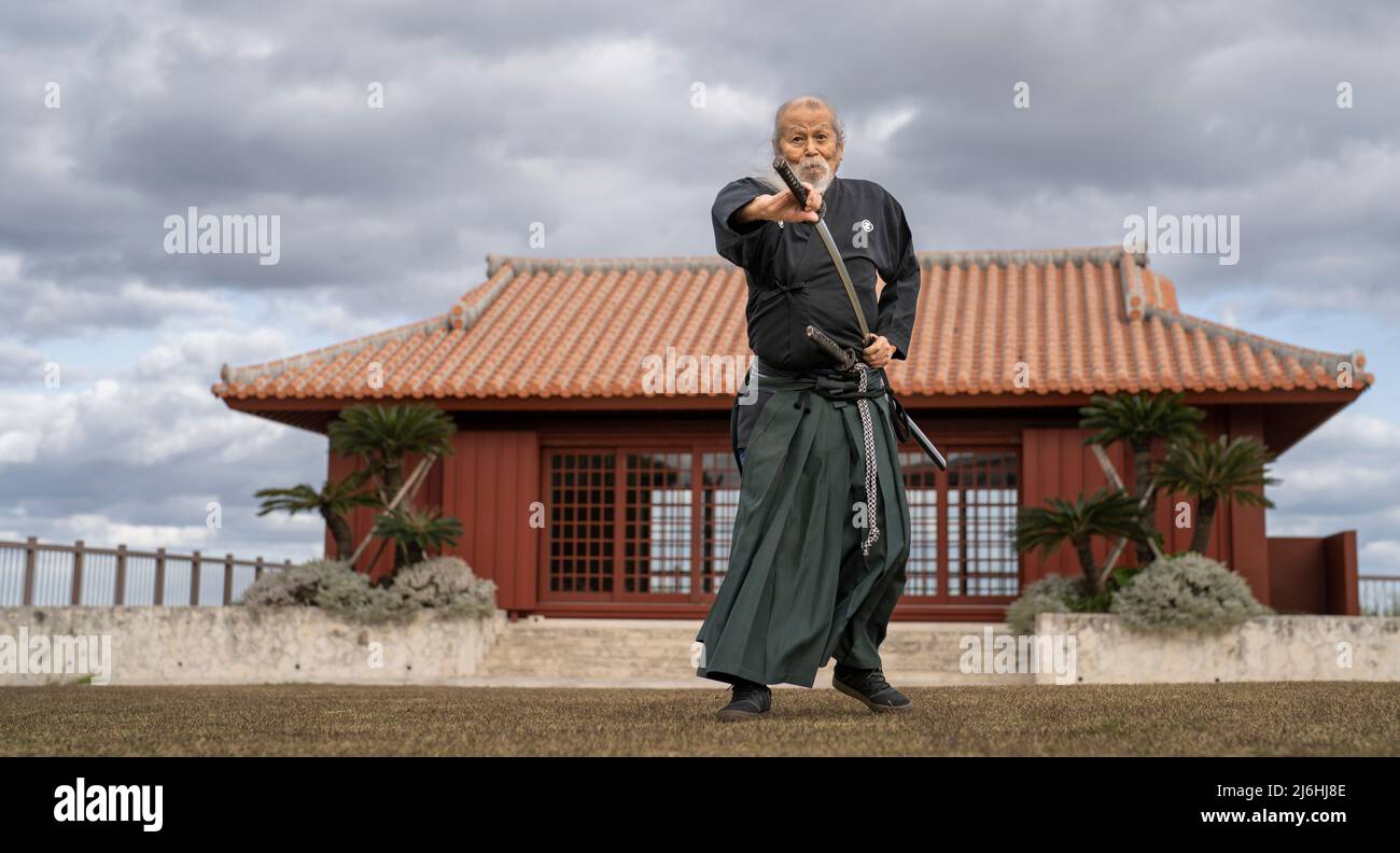 Hamamoto Sensei un maître de l'entraînement d'iaido avec son katana au Karate Kaikan, Okinawa, Japon Banque D'Images