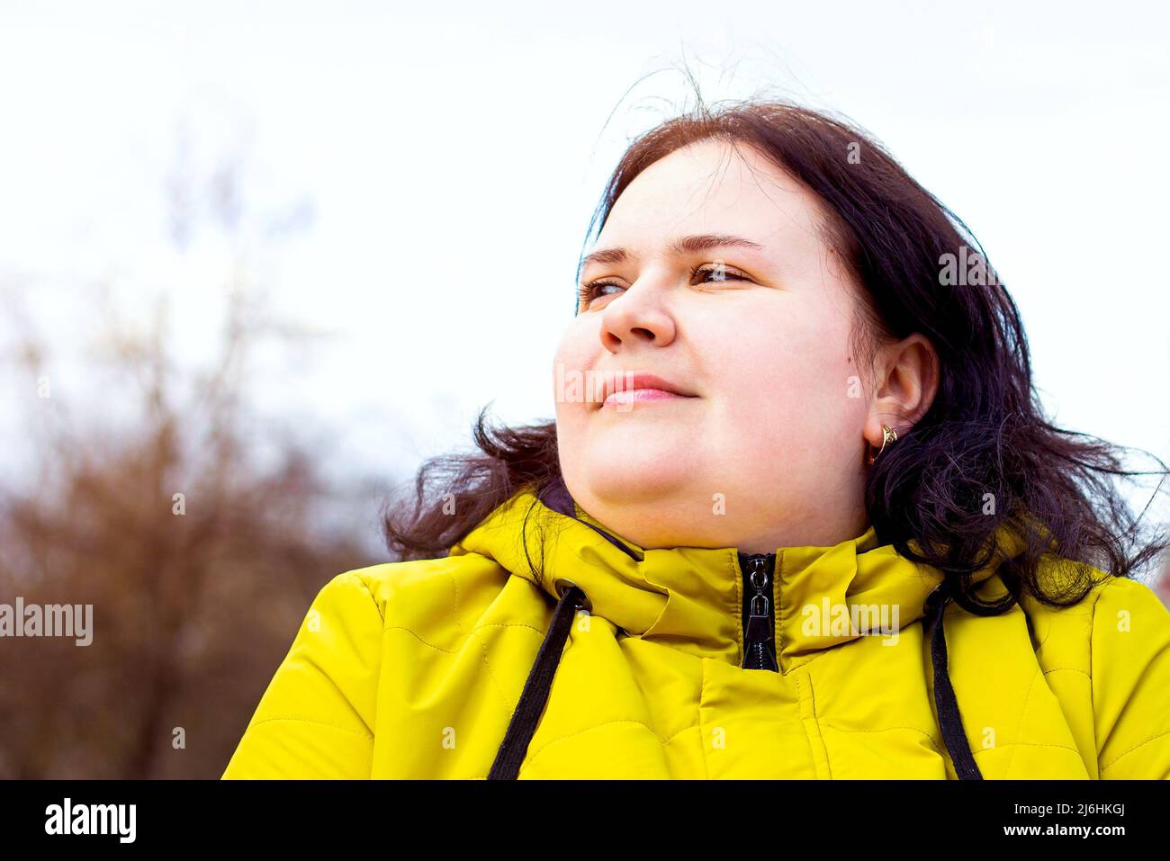 Heureux attrayant chubby surpoids femme caucasienne souriant portrait à l'extérieur. Une personne joyeuse, plutôt positive pour le corps, riant pendant la promenade dans le parc. Banque D'Images