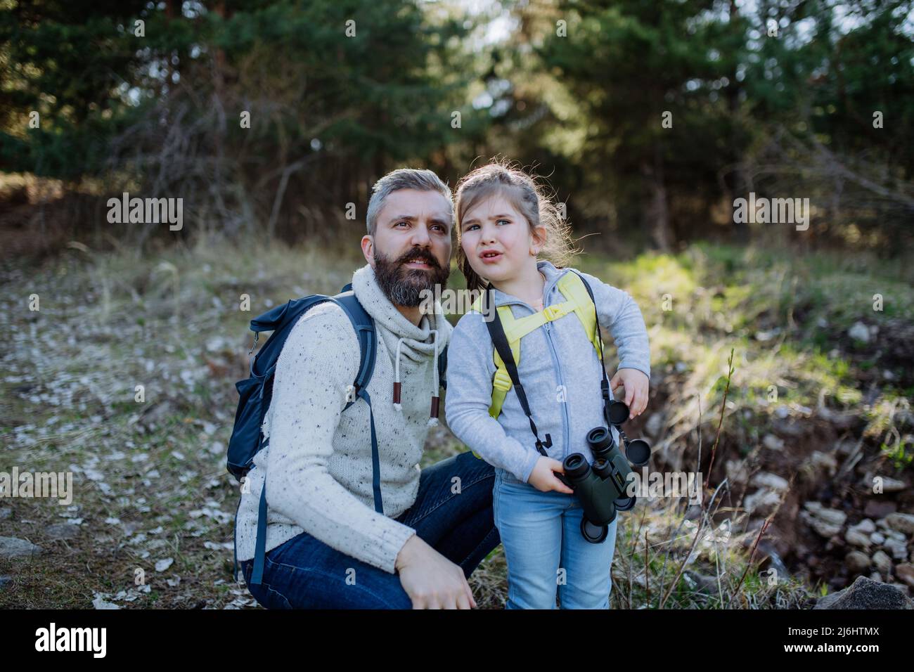 Père avec petite fille avec des jumelles sur la marche dans la nature de printemps ensemble. Banque D'Images