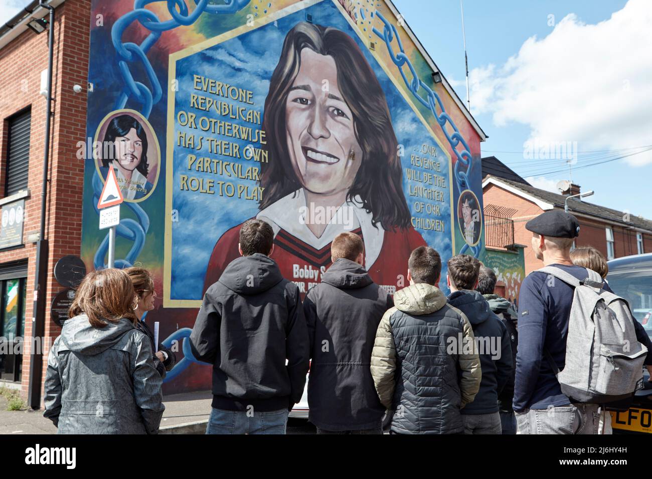Groupe de touristes d'Espagne à la fresque de Bobby Sands sur le mur du bureau de Sinn Fein, Lower Falls Road, West Belfast, Irlande du Nord, 20th Apri Banque D'Images
