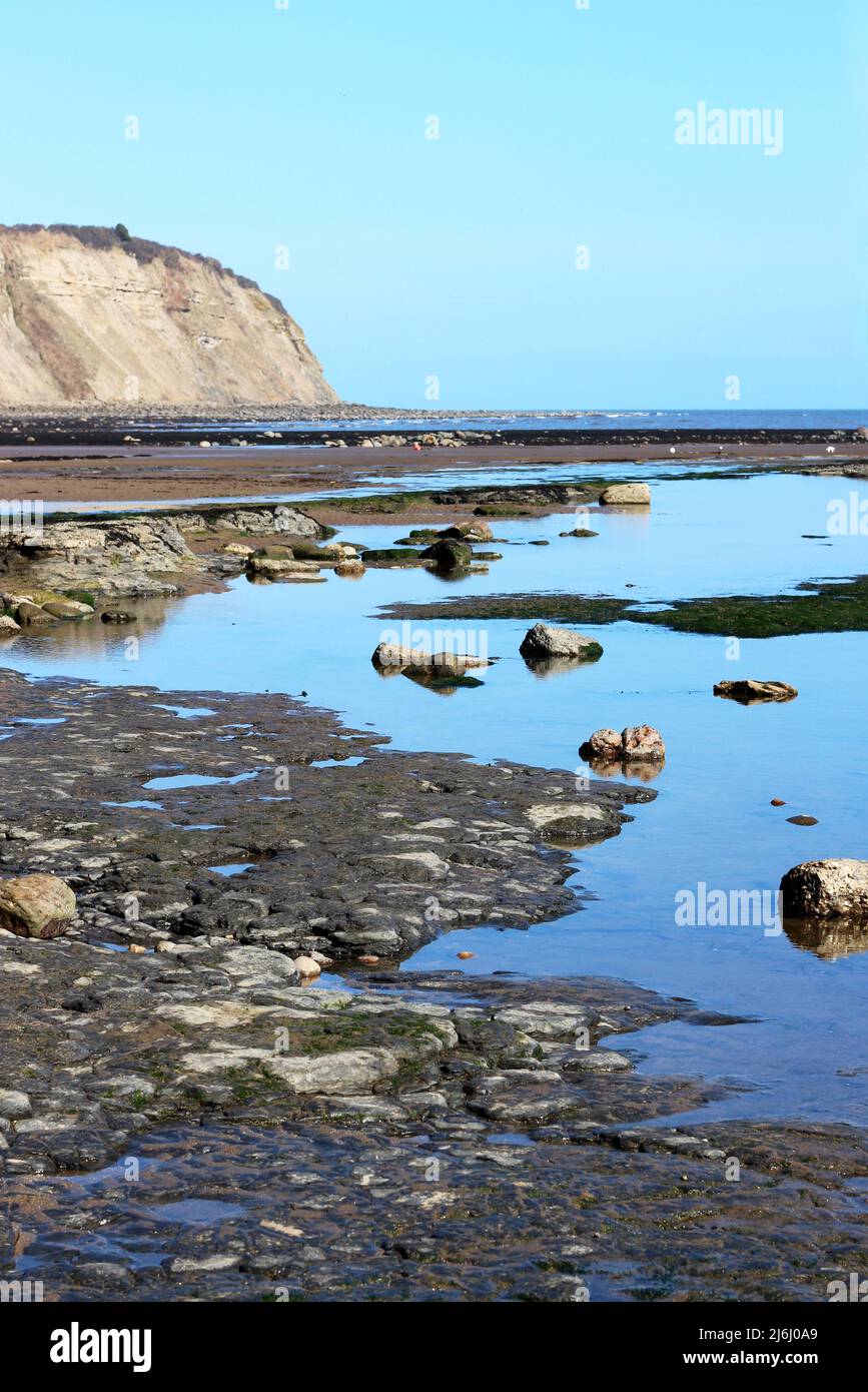 Les piscines de rochers et la mer étincelant de Robin des Bois's Bay, Yorkshire, Royaume-Uni Banque D'Images
