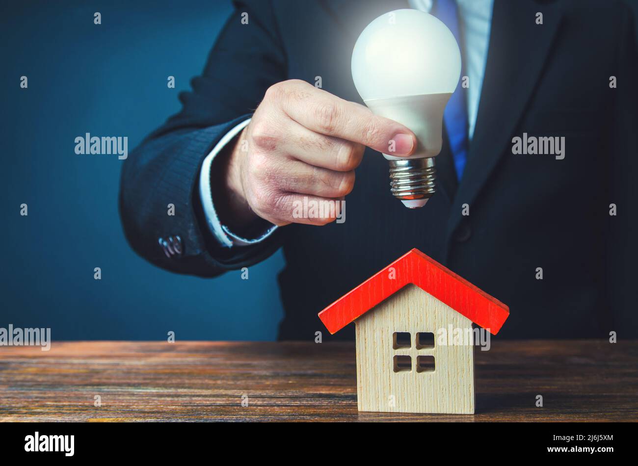 Ampoule lumineuse au-dessus de la maison. Une maison écologique intelligente. Alimentation électrique. Paiement des factures en temps opportun. Entreprises de services publics. Idées pour la maison. Innovations et Banque D'Images