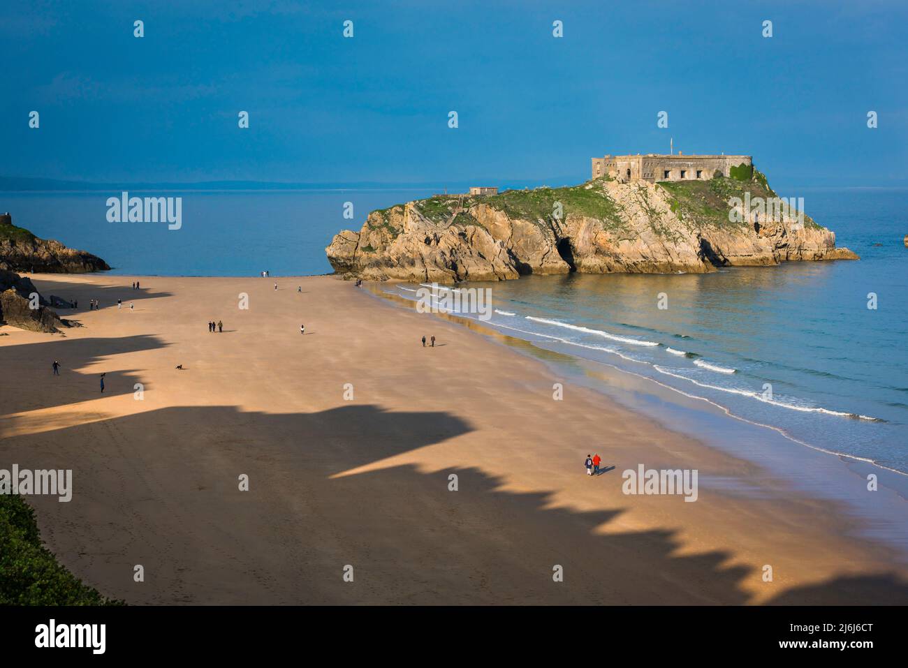 Tenby South Beach, vue sur une soirée d'été de personnes marchant sur South Beach avec l'île Sainte-Catherine à proximité, Tenby, Pembrokeshire, pays de Galles Banque D'Images