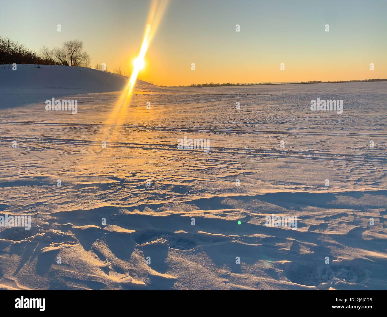 Coucher de soleil sur un terrain enneigé. Hiver Banque D'Images