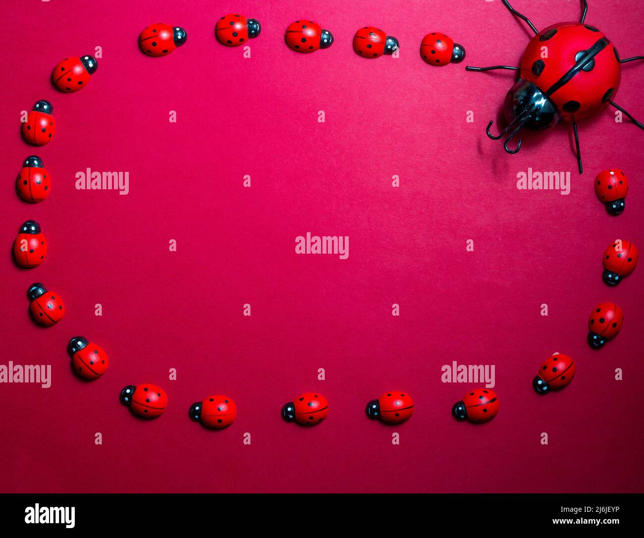 petits et grands ladybirds jouet sur un fond rouge, espace de copie . Banque D'Images