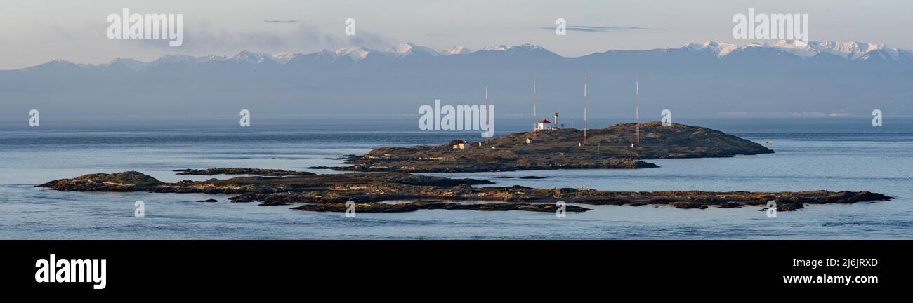 Les îles Trial avec le phare des îles Trial, un groupe d'antennes radio, et les montagnes olympiques à l'horizon. Banque D'Images