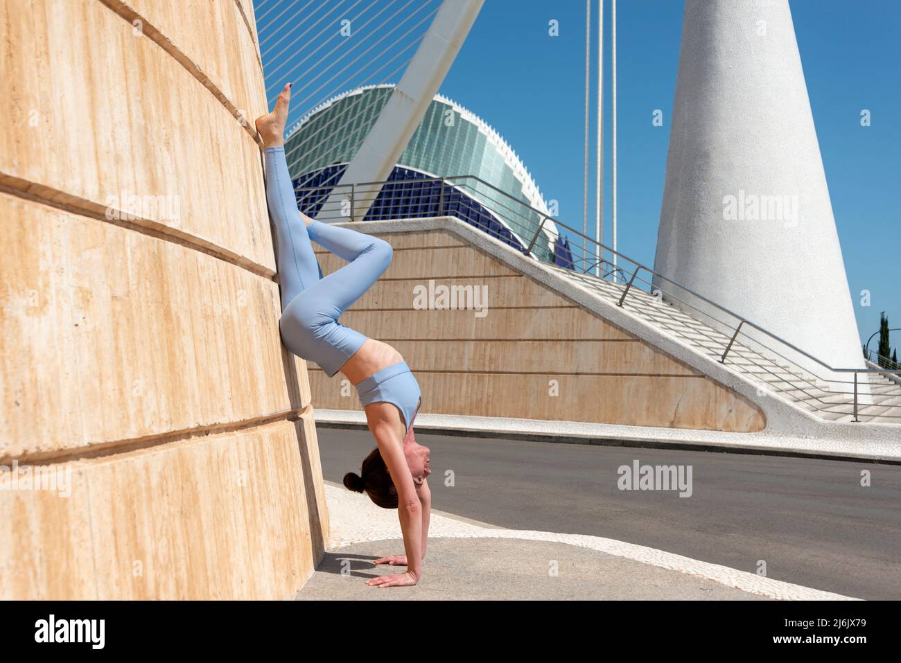 FIT femme faisant une main contre un mur à la Cité des Arts et des Sciences, Valence, Espagne. Banque D'Images