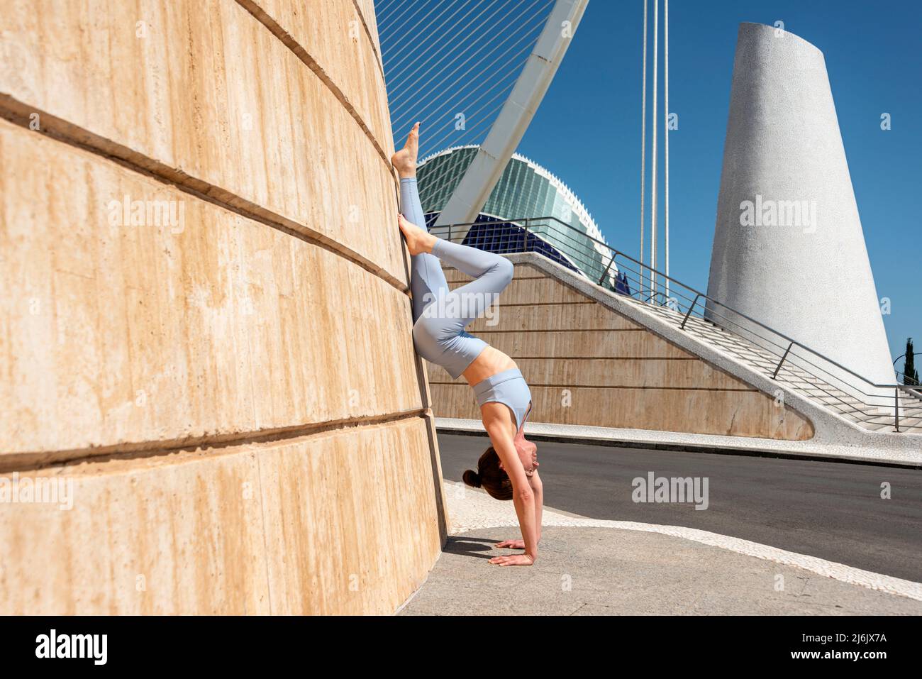 FIT femme faisant une main contre un mur à la Cité des Arts et des Sciences, Valence, Espagne. Banque D'Images