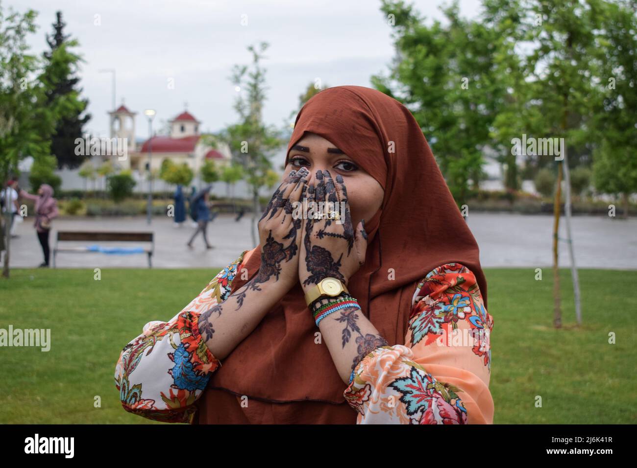 2 mai 2022, Athènes, Grèce: Une femme après avoir terminé la prière d'Eid al-Fitr à la mosquée représente une photo montrant ses mains décorées de henné tandis qu'une église orthodoxe grecque peut être vue en arrière-plan. Les fidèles se réunissent pour exécuter la prière d'Eid al-Fitr à la mosquée officielle de la capitale grecque. (Credit image: © Dimitris Aspiotis/Pacific Press via ZUMA Press Wire) Banque D'Images