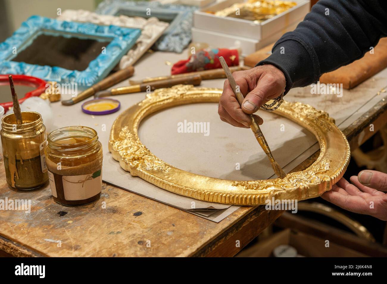 Application d'une feuille d'or à un cadre. Technique du processus de dorure. Banque D'Images