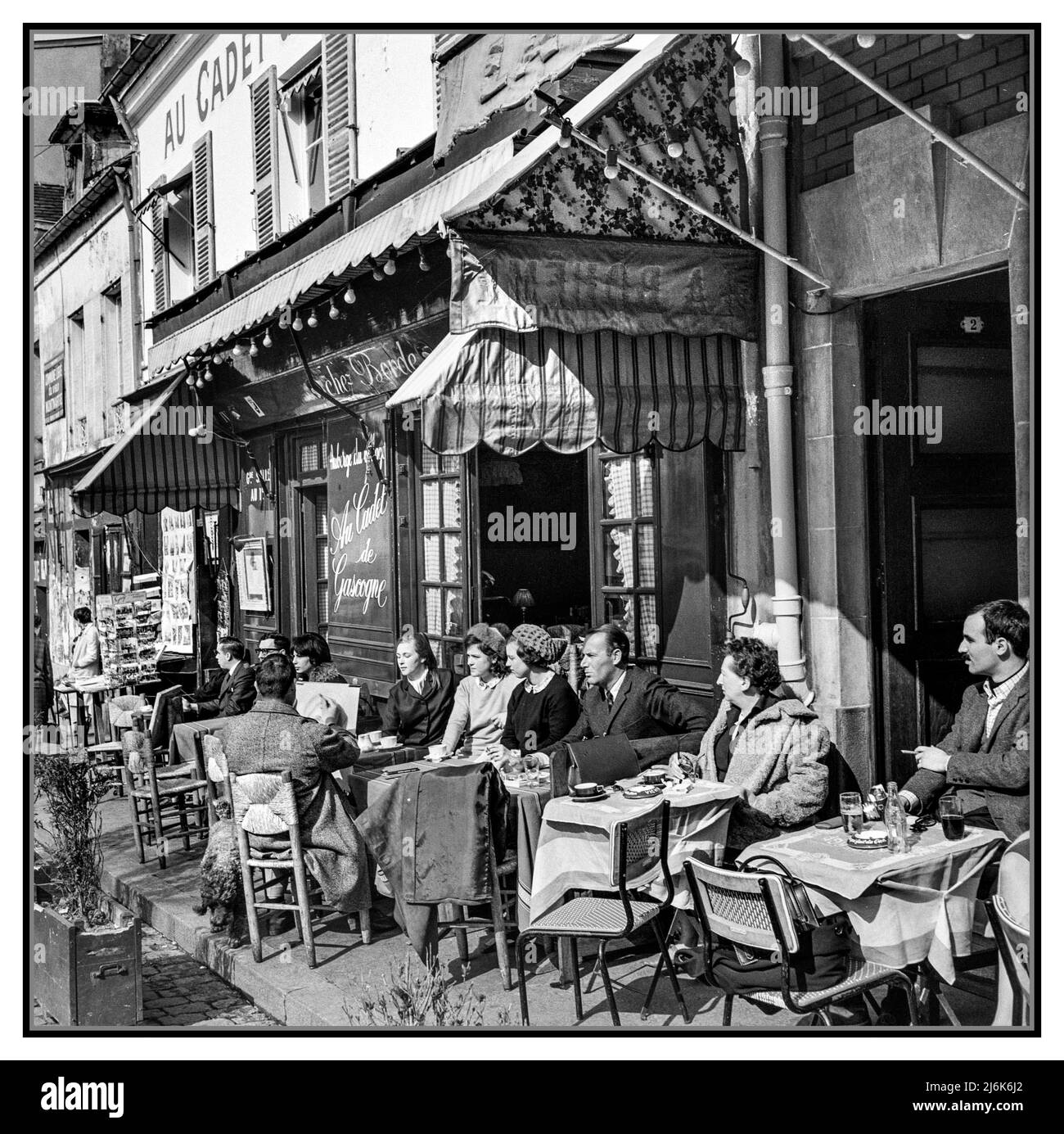 Paris Montmartre Cafe Restaurant des années 1960 terrasse en plein air avec buveurs et dîners assis à des tables. Street artiste dessinant un portrait à table place du Tertre Montmartre Paris France 1965 Willem van de Poll photographe Banque D'Images