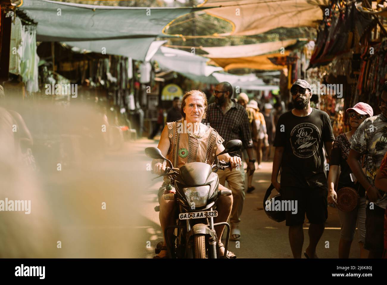 Anjuna, Goa, Inde - 19 février 2020 : l'ancien homme à bord d'une moto Scooter sur le marché Anjuna Banque D'Images
