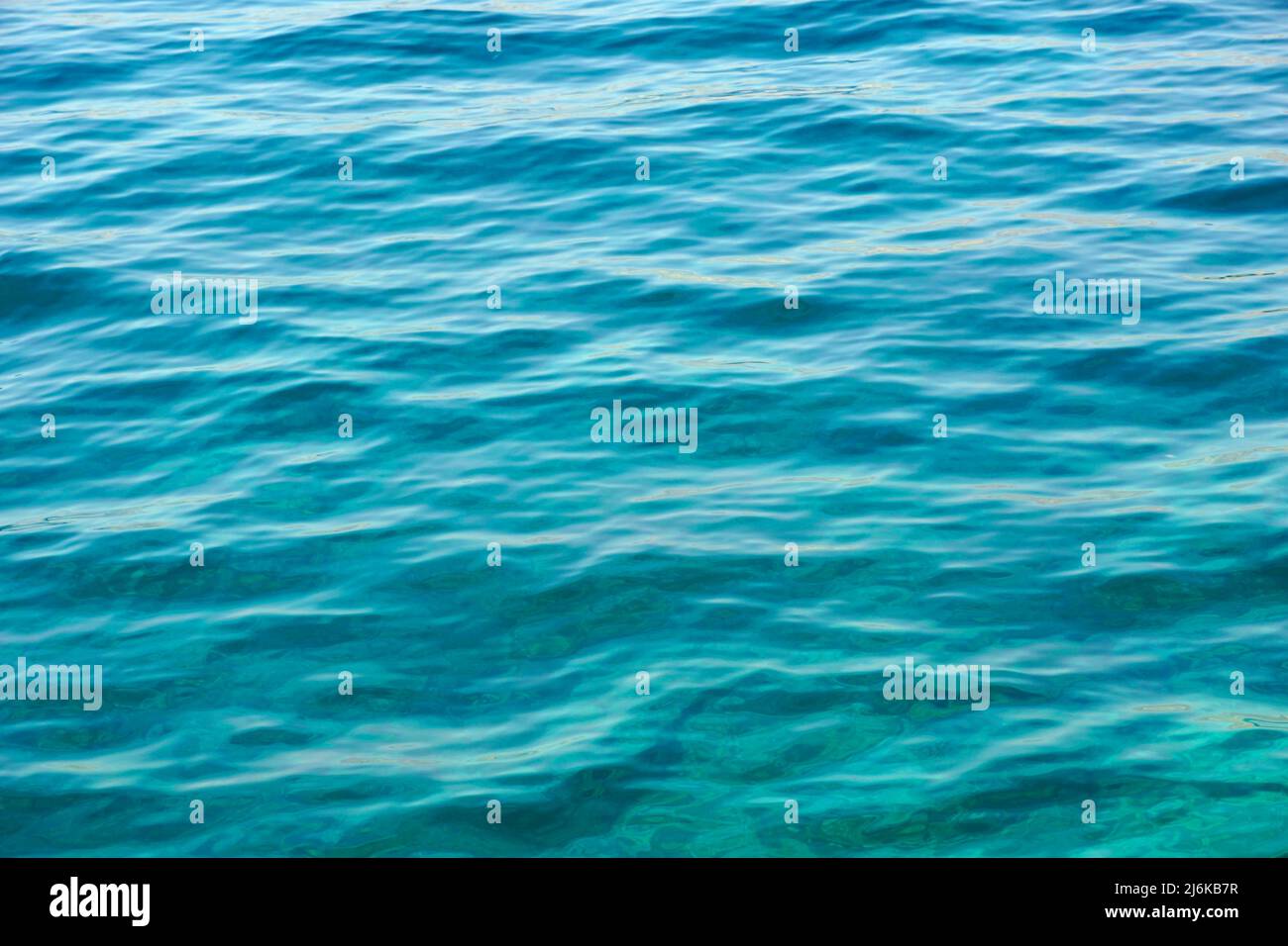 Magnifique arrière-plan abstrait avec surface turquoise transparente de l'eau de mer peu profonde Banque D'Images