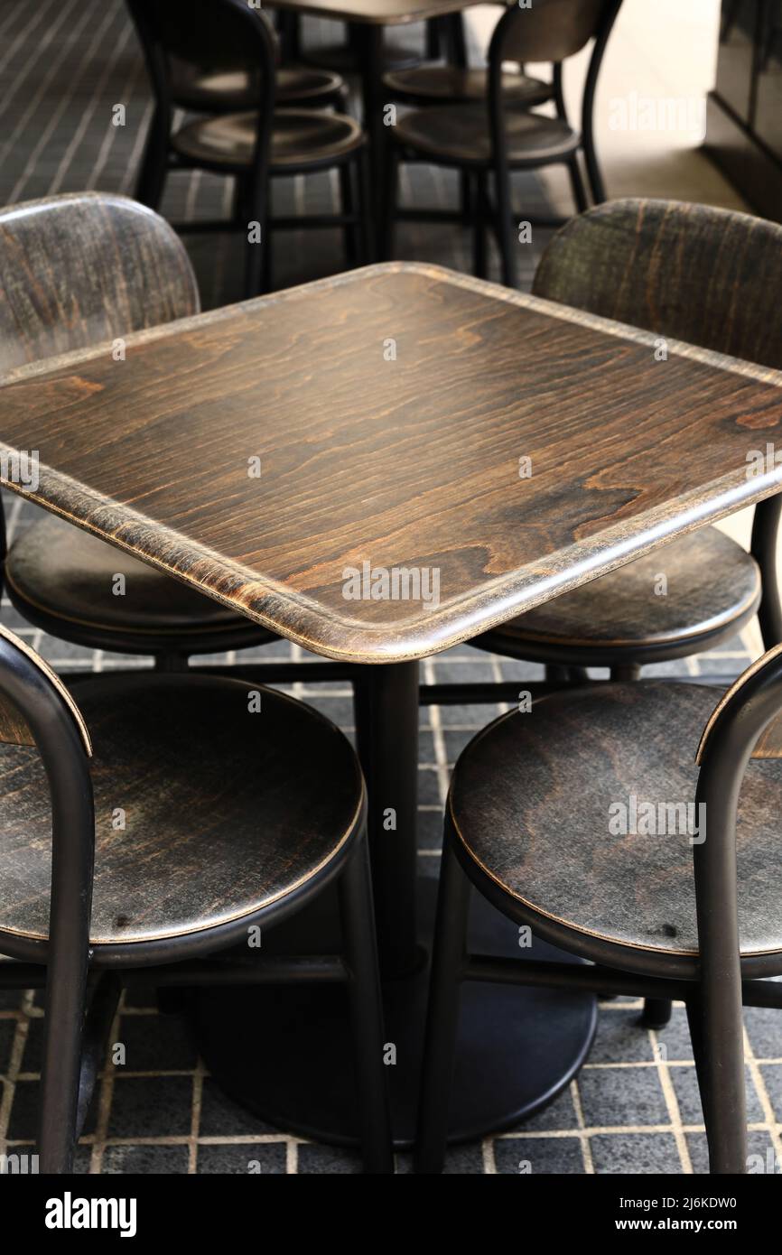 Les tables de café sont parfaitement alignées sur une terrasse vide Banque D'Images