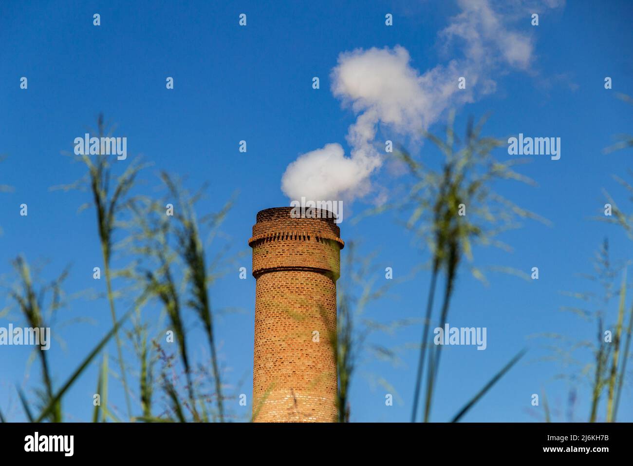 Goias, Brésil – 01 mai 2022 : cheminées industrielles émettant de la fumée blanche dense. Ventilateur d'extraction industriel émettant de la fumée avec ciel bleu. Banque D'Images