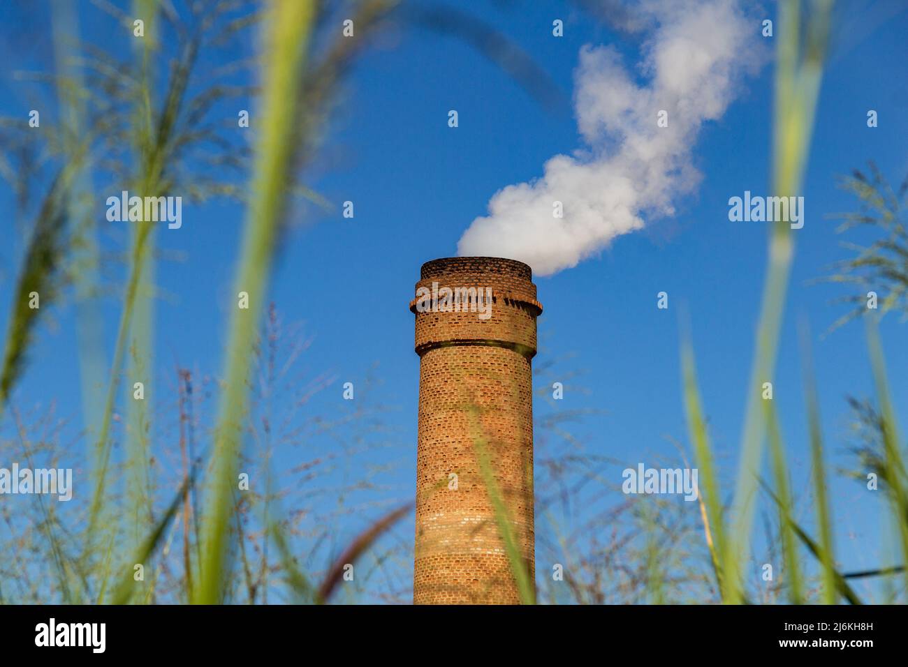 Goias, Brésil – 01 mai 2022 : cheminées industrielles émettant de la fumée blanche dense. Ventilateur d'extraction industriel émettant de la fumée avec ciel bleu. Banque D'Images