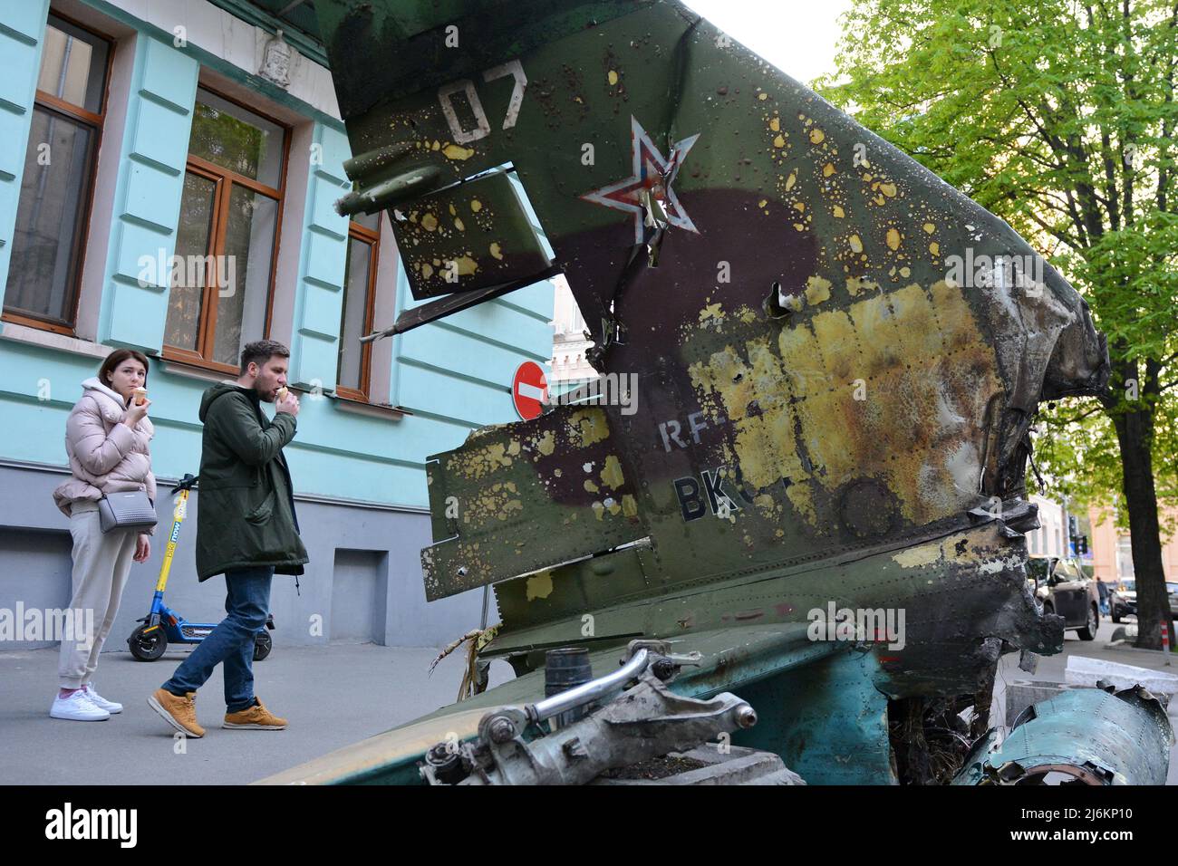 Région de Kiev, Ukraine - 02 mai 2022, Un couple inspecte une queue fragmente d'un avion militaire russe SU-25, qui a été détruit par l'armée ukrainienne dans la région de Kiev. La Russie a envahi l'Ukraine le 24 février 2022, déclenchant la plus grande attaque militaire en Europe depuis la Seconde Guerre mondiale Banque D'Images