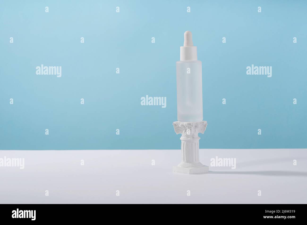 Flacon cosmétique de sérum avec peptides et rétinol sur pied de podium sur fond bleu. Produit cosmétique acide hyaluronique maquette d'emballage avec Banque D'Images