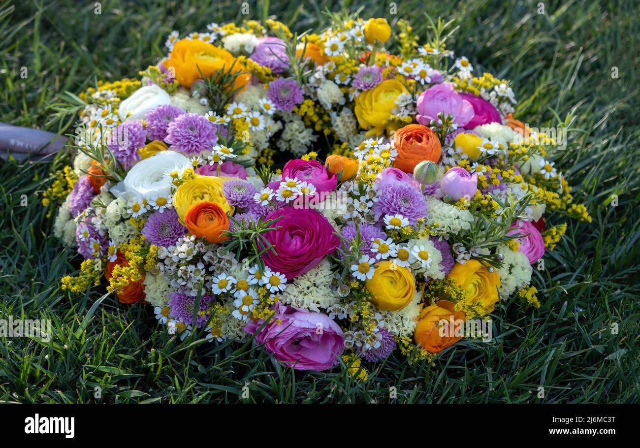 Couronne de fleurs sur l'herbe verte. Fleurs sauvages et herbes fraîches sur la pelouse du jardin, vue rapprochée. Jour de printemps. Fête des femmes ou des mères Banque D'Images