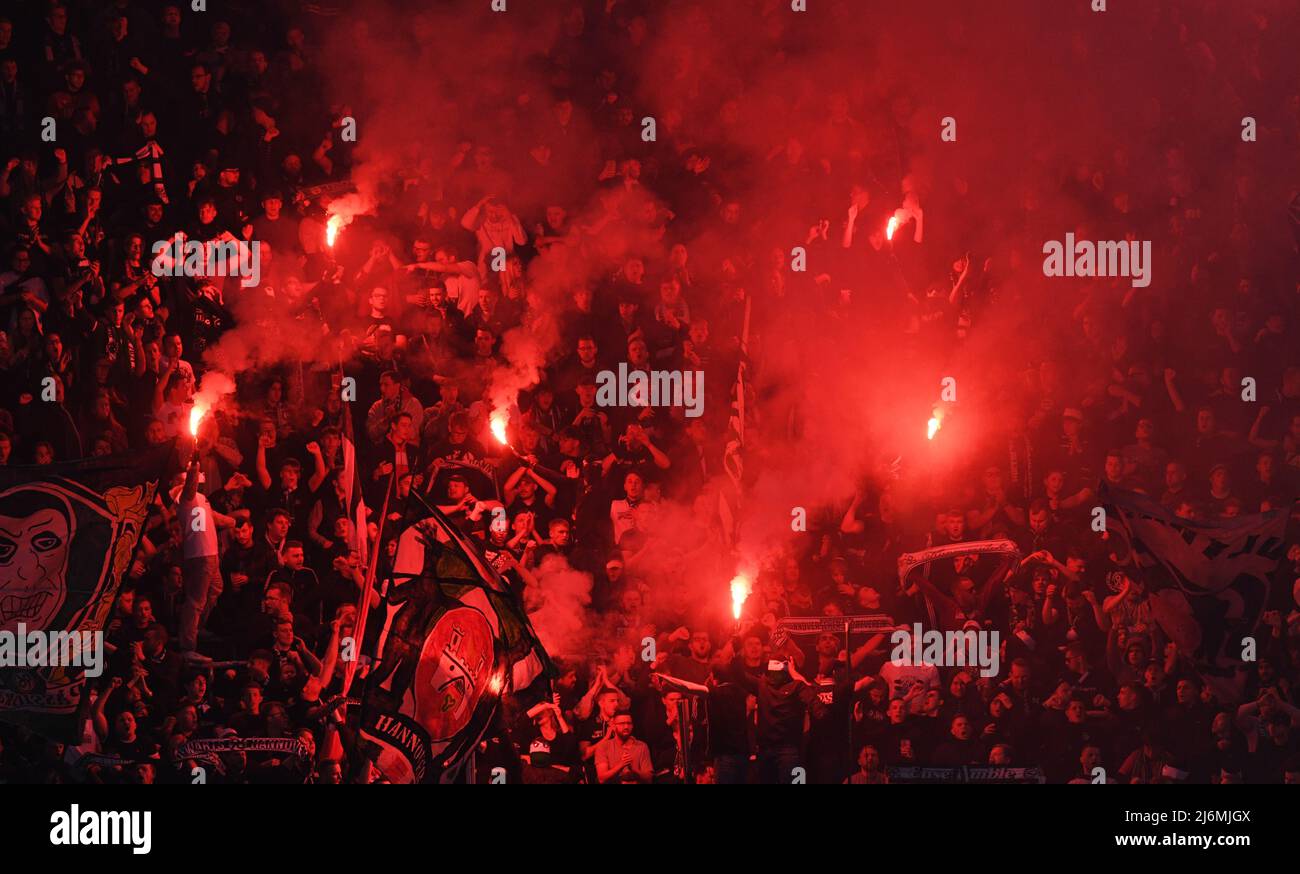 29 avril 2022, Basse-Saxe, Hanovre: Football: 2nd Bundesliga, match de 32: Hanovre 96 - Karlsruher SC à l'HDI Arena. Les fans de Hanovre brûlent des pétards. Photo: Daniel Reinhardt/dpa - NOTE IMPORTANTE: Conformément aux exigences de la DFL Deutsche Fußball Liga et de la DFB Deutscher Fußball-Bund, il est interdit d'utiliser ou d'avoir utilisé des photos prises dans le stade et/ou du match sous forme de séquences d'images et/ou de séries de photos de type vidéo. Banque D'Images