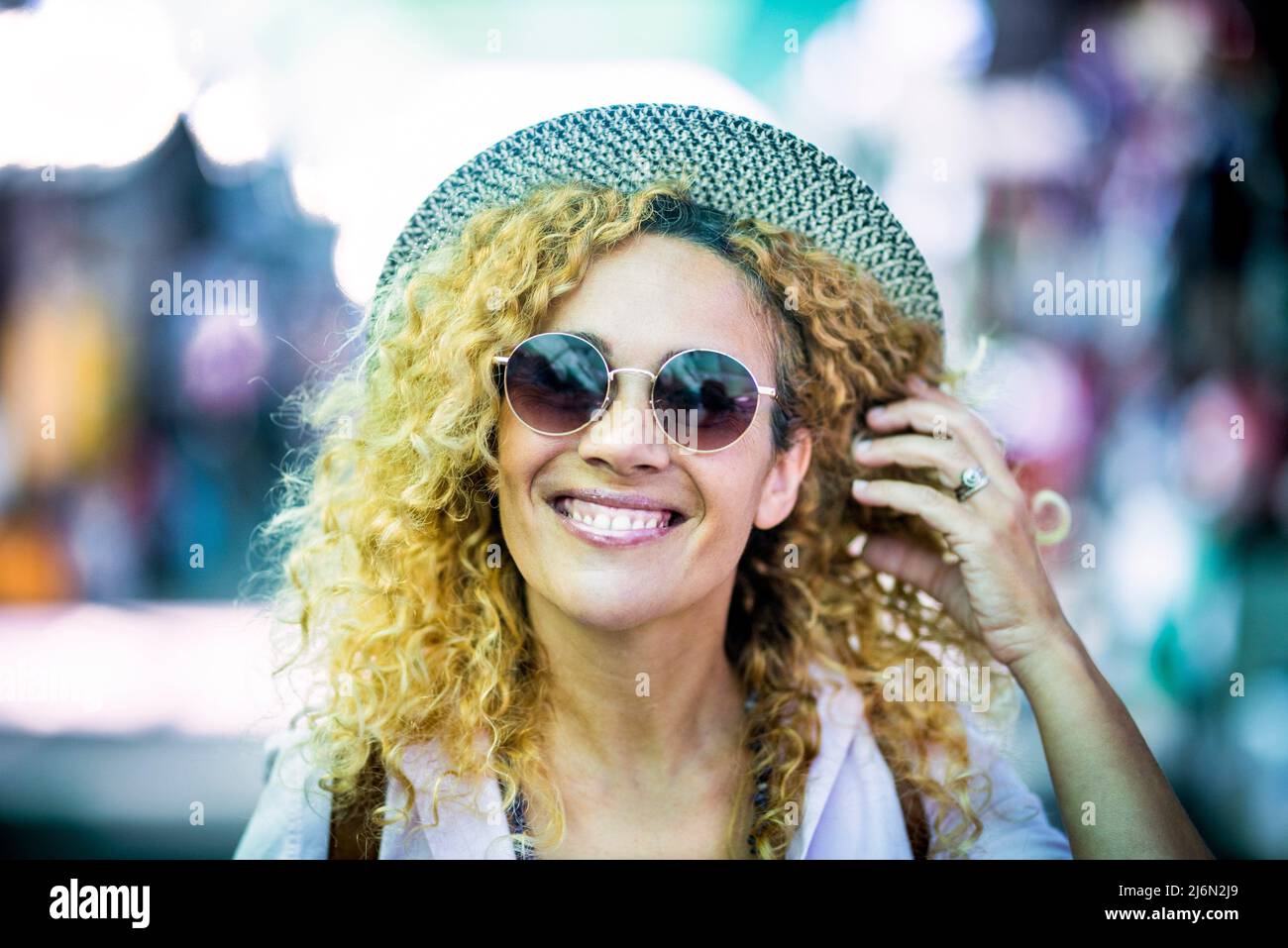 Joyeux beau portrait de jeune femme avec chapeau tendance et lunettes de soleil Profitez des activités de loisirs en plein air et regarder sur l'appareil photo. Banque D'Images