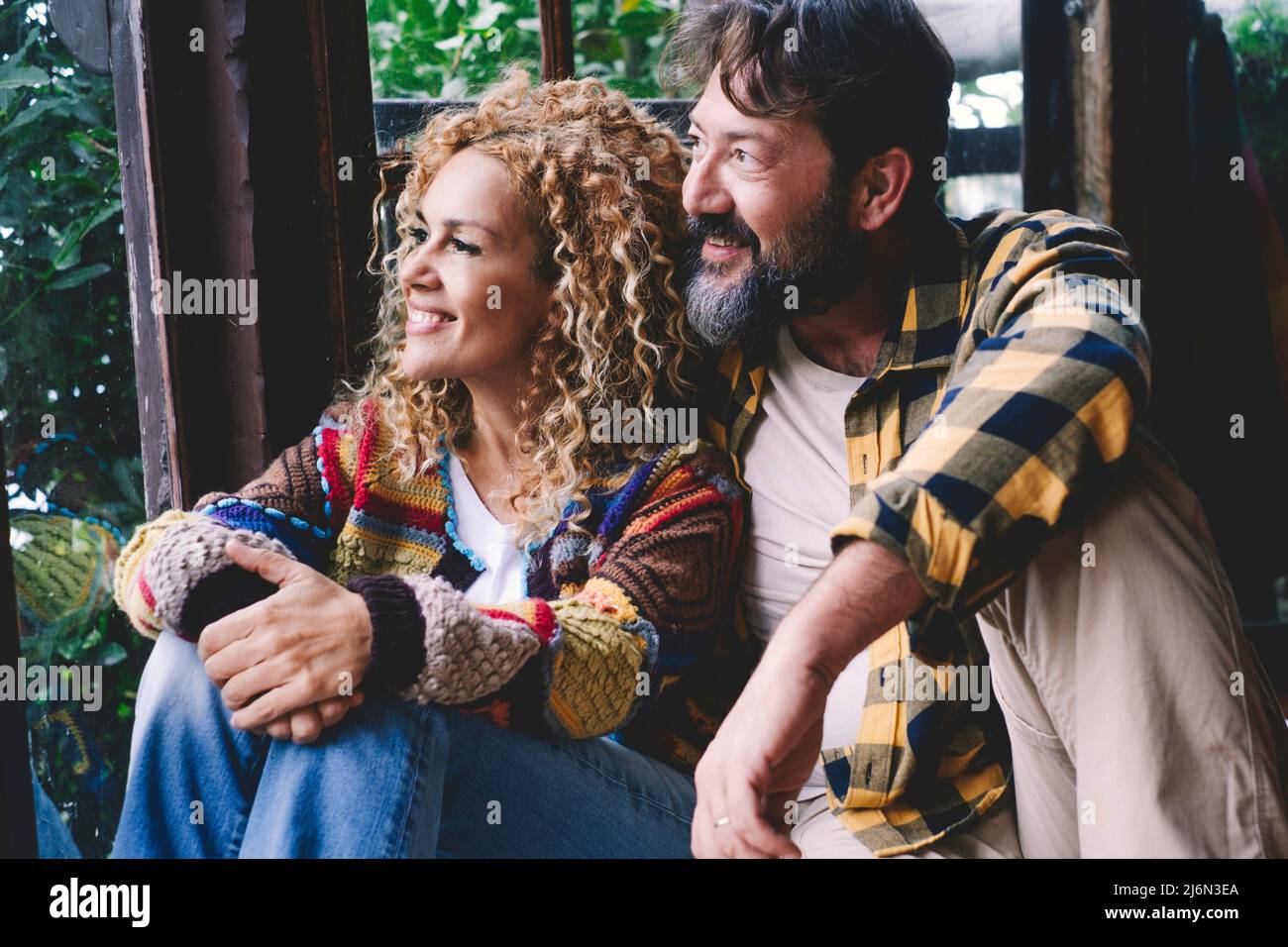Relation et amour avec l'homme heureux et la femme couple caucasien assis à la maison près de la fenêtre avec la nature verte à l'extérieur. Amour et Banque D'Images