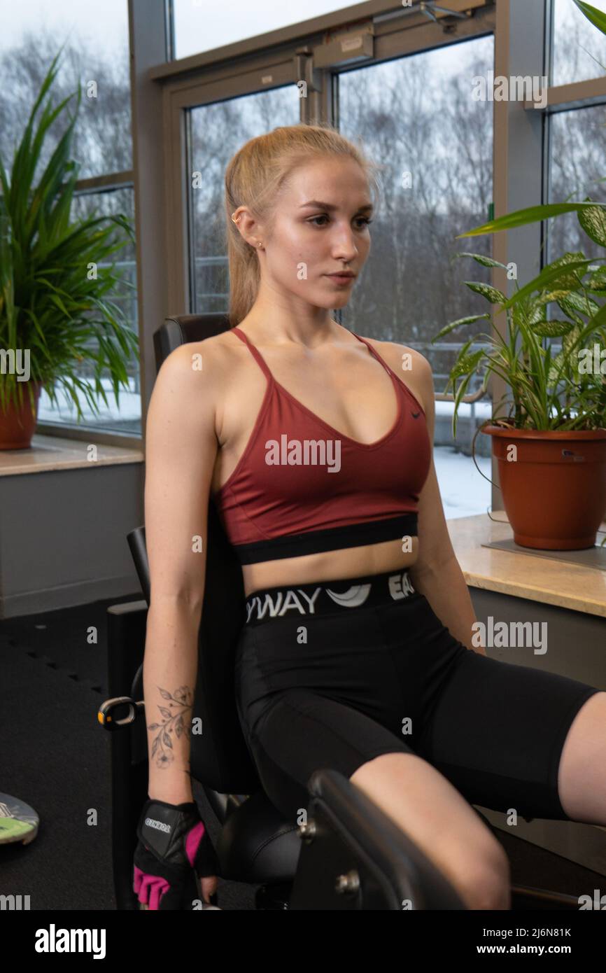 RUSSIE, MOSCOU - 11 FÉVRIER 2022: L'entraînement dirigé par un instructeur aide un beau client à effectuer des exercices dans un club de fitness, le concept de jouer du sport Banque D'Images