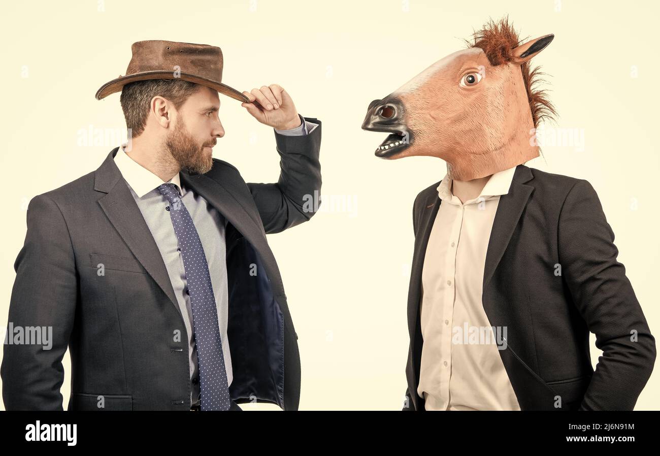 Si cool. Les hommes d'affaires bizarres portent une tête de cheval et un chapeau de cow-boy. Halloween d'entreprise. Parti d'entreprise Banque D'Images