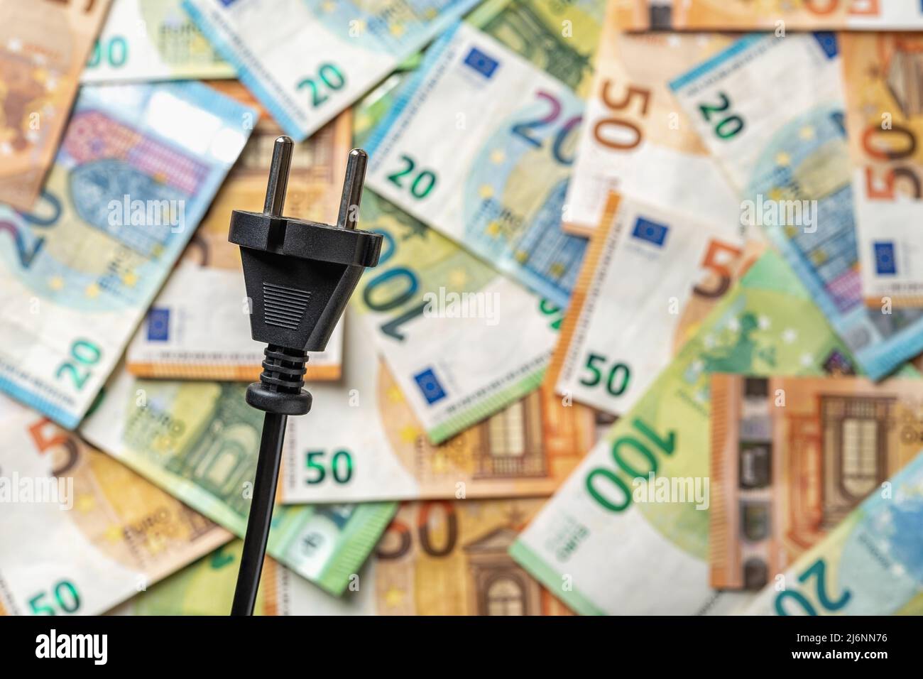 Fiche d'alimentation de l'appareil sur fond de billets en euros avec espace de copie. Crise du pouvoir et inflation. Augmentation des coûts énergétiques et de chauffage. Banque D'Images