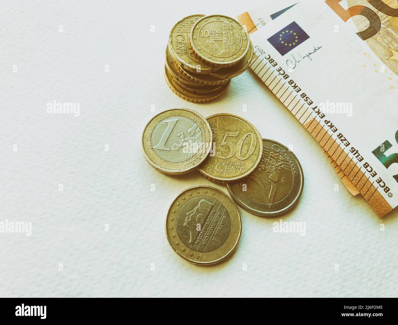 Concept de billets et pièces en euros sur fond blanc. Monnaie européenne. Pièces de 1 euros, 2 euros et cents. 50 billets en euros Banque D'Images