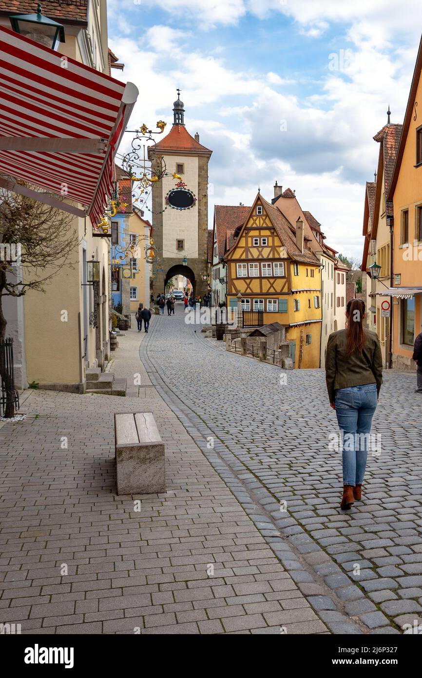 Belle architecture romantique de Rothenburg ob der Tauber avec maisons à colombages Fachwerkhaus syle en Bavière Allemagne avec une touriste marchant. Banque D'Images