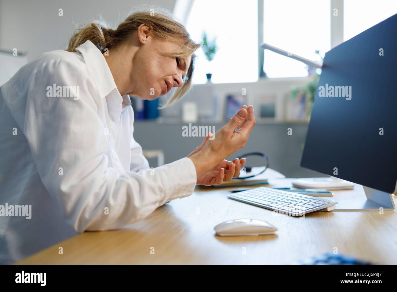 Femme de bureau avec syndrome de canal carpien et douleur de poignet Banque D'Images