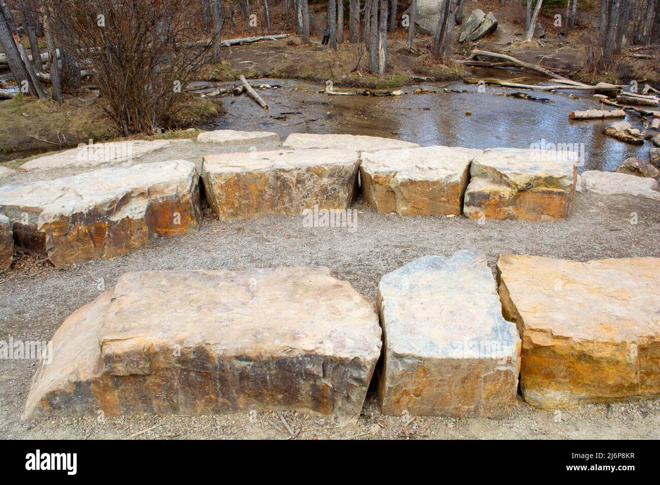 Place assise en pierre naturelle le long de la crique dans le parc naturel. Banque D'Images