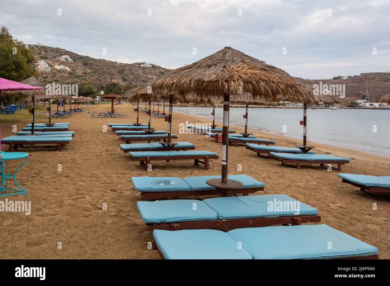 Des chaises longues et des parasols sont installés sur la plage de sable de Chora, sur l'île d'iOS. Cyclades, Grèce Banque D'Images