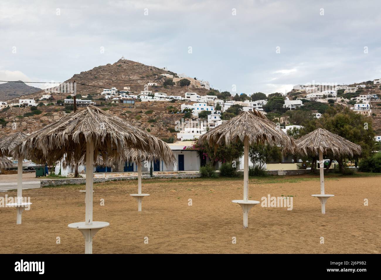 Parasols en paille sur la plage de sable de Chora sur l'île d'iOS. Cyclades, Grèce Banque D'Images