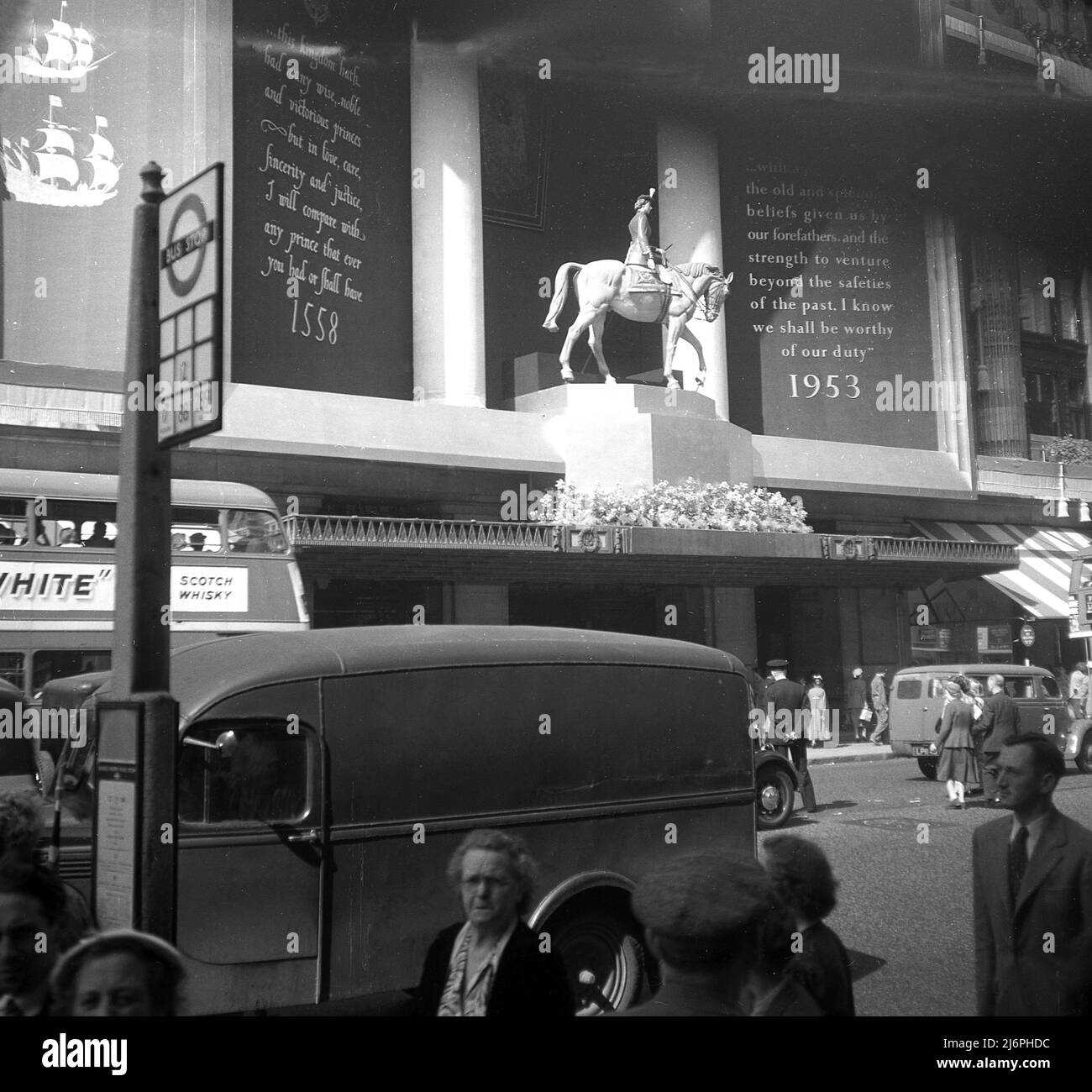 1953, historique, Oxford Street, Londres, Angleterre, Royaume-Uni, exposition extérieure sur un grand magasin célébrant le couronnement de la reine Elizabeth II sur le trône. La soi-disant décoration du Couronnement de Selfridges était une statue équestre de la reine Elizabeth II sur son cheval 'Winston'. Banque D'Images