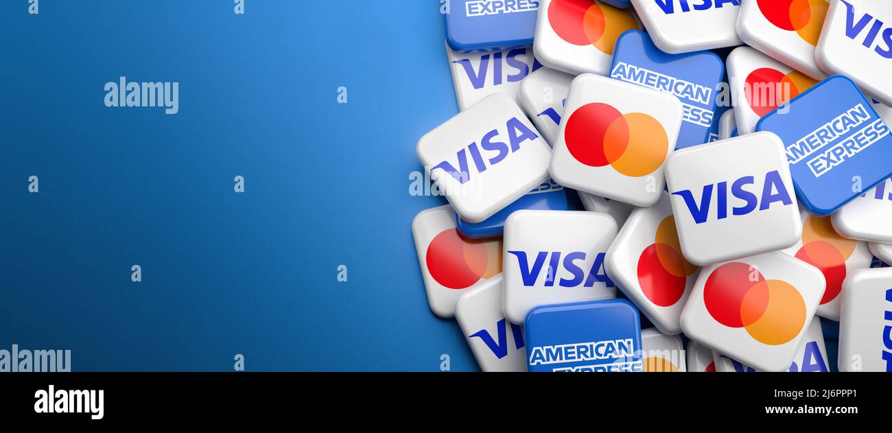Logos des sociétés concurrentes de cartes de crédit Visa, Mastercard et American Express sur un tas sur une table. Copier l'espace. Format de bannière Web. Banque D'Images