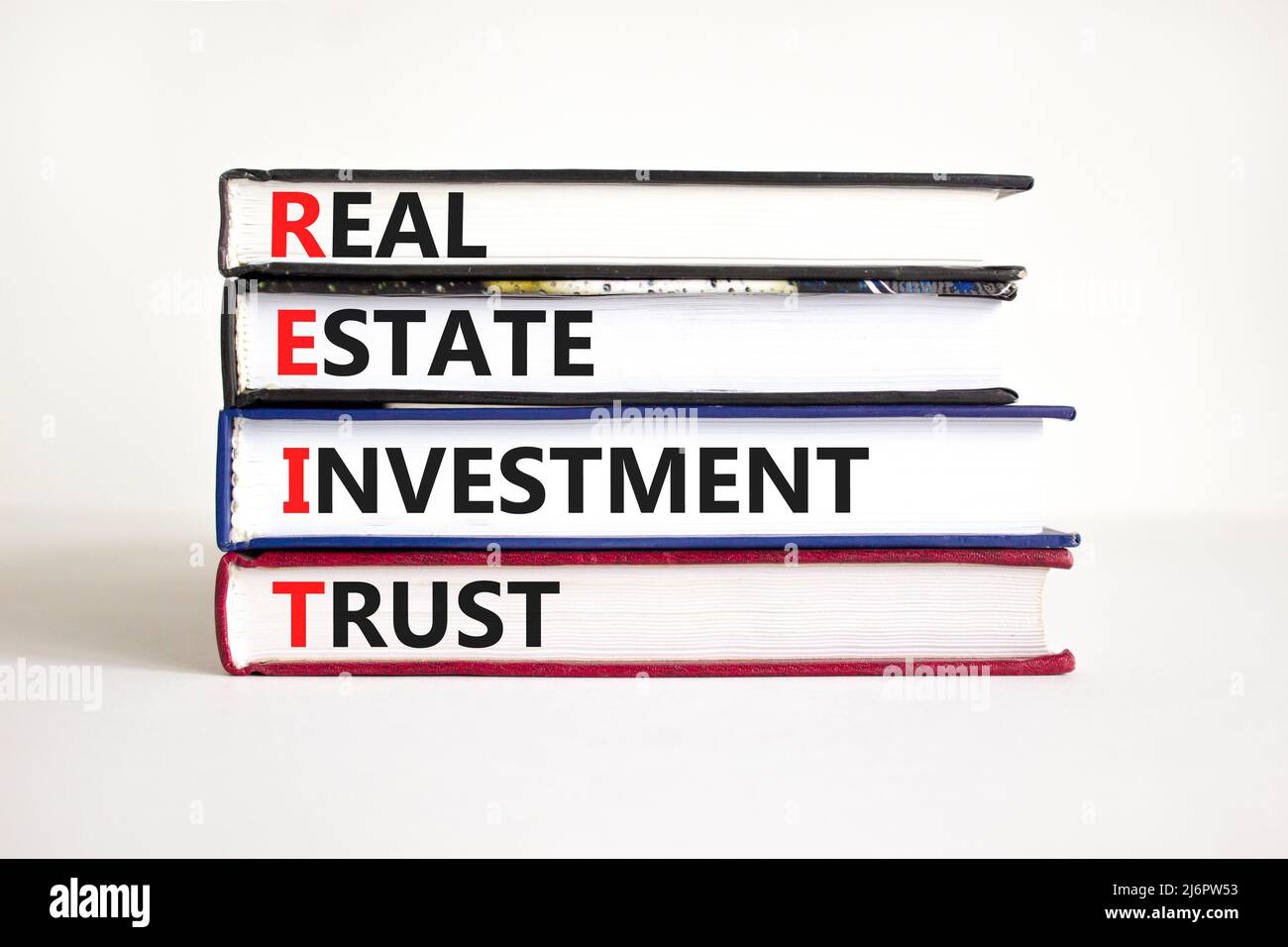 Symbole de fiducie de placement immobilier REIT. Mots de concept REIT investissement immobilier confiance sur des livres sur beau blanc table fond blanc. Entreprise Banque D'Images