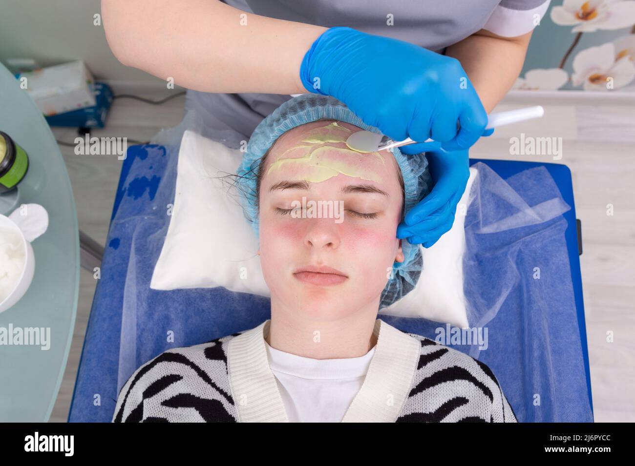 Le cosmétologue applique un masque d'alginate avec une spatule sur le visage de la femme. Soin du visage et traitement anti-âge. Cosmétologie et soin professionnel de la peau du visage Banque D'Images