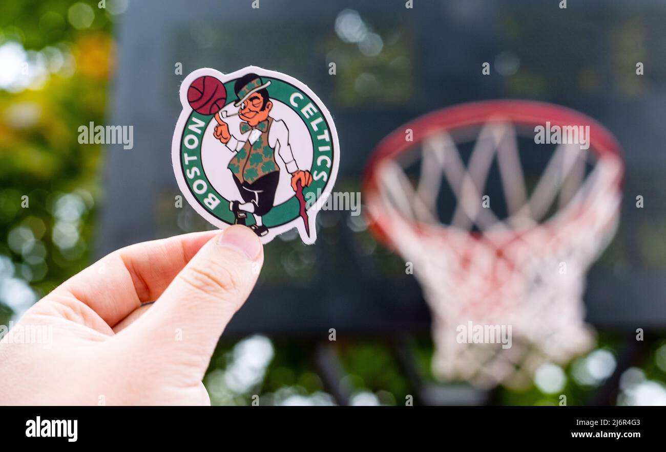 15 septembre 2021, Boston, USA, Un homme tient le logo du club de basket-ball Boston Celtics dans sa main sur le terrain sportif. Banque D'Images