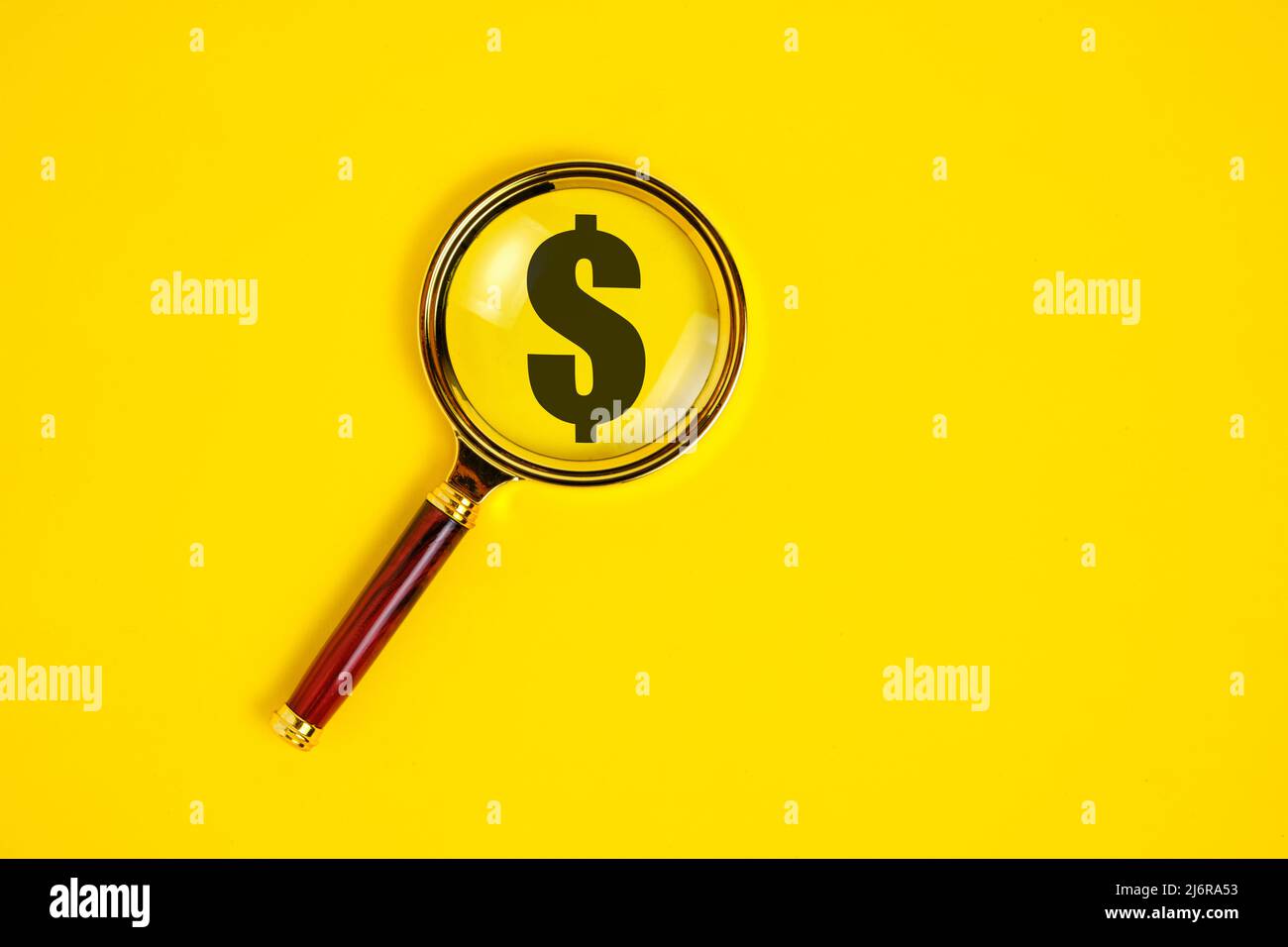 Symbole dollar sous une loupe, sur fond jaune Banque D'Images