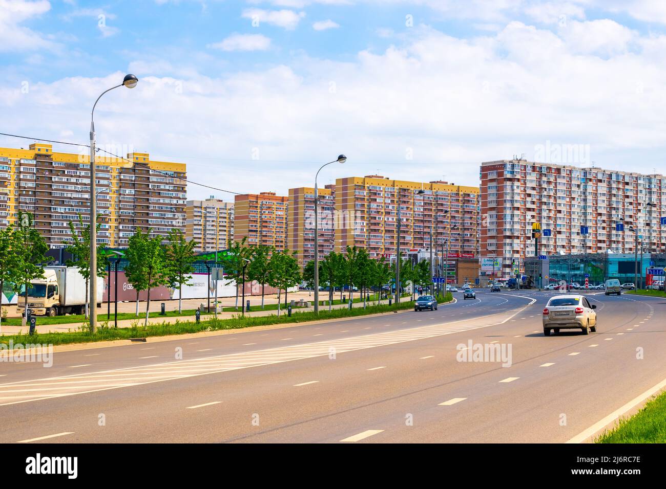 Rues de la ville avec circulation en mouvement sur une route à plusieurs voies et de hauts bâtiments résidentiels. Krasnodar, Russie-28.04.2022 Banque D'Images