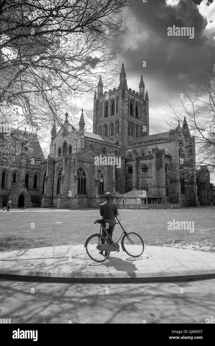 Statue en bronze d'Edward Elgar, adossé à un vélo dans le parc de la cathédrale de Hereford, Hereford, Herefordshire, Angleterre. Banque D'Images