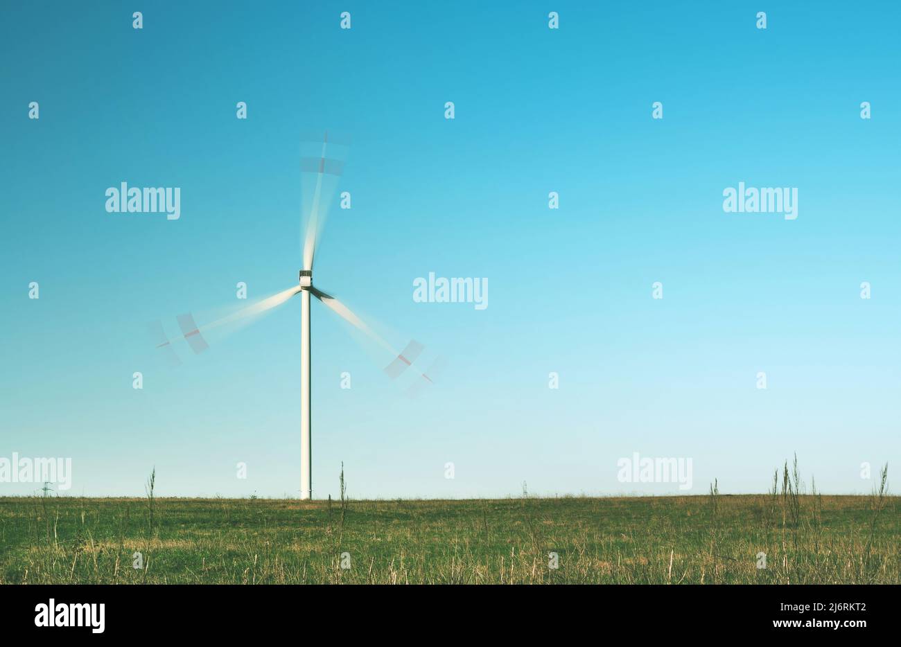 déplacement de l'éolienne solitaire dans le champ vert Banque D'Images