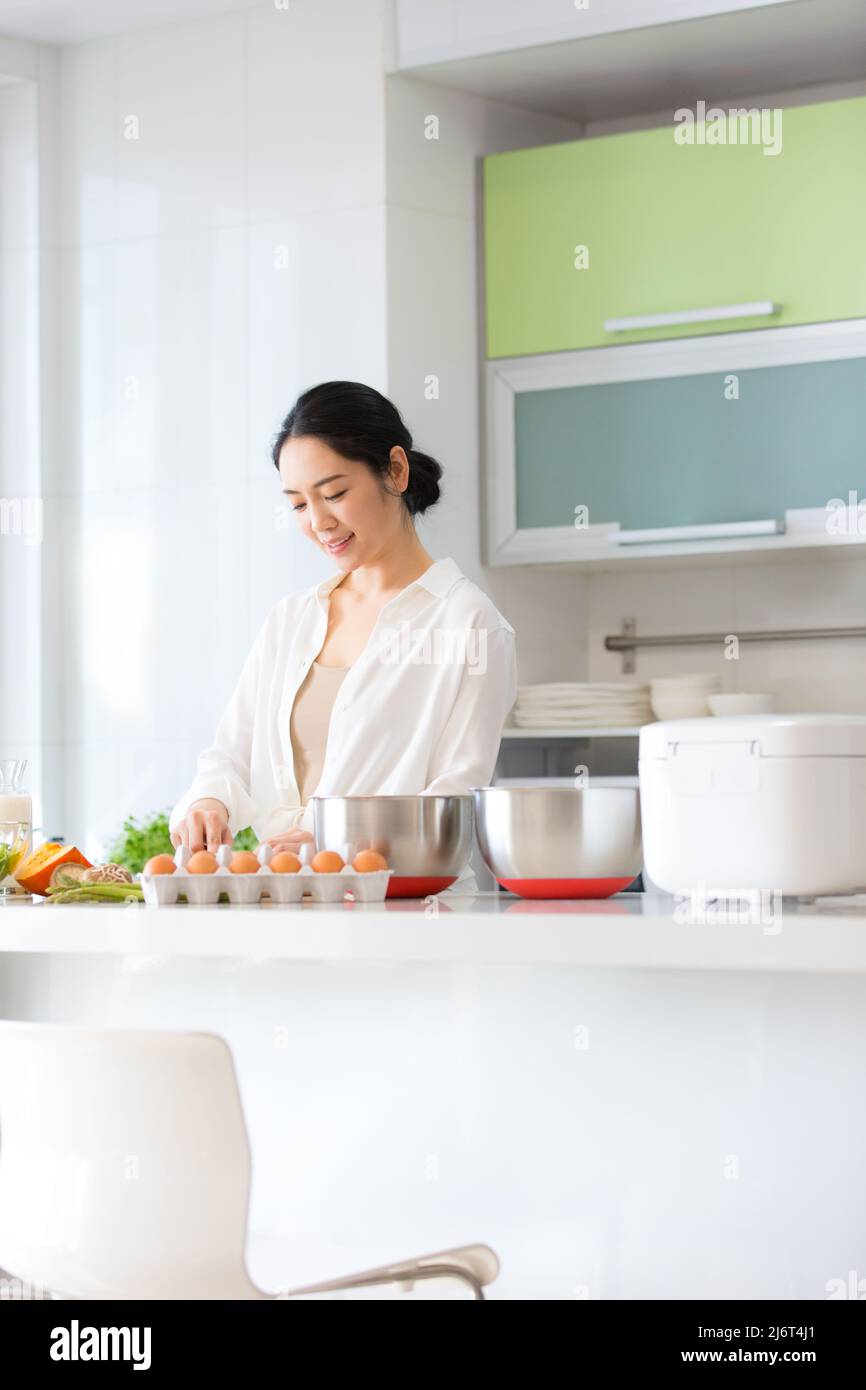 Jeune femme de ménage préparant la nourriture dans la cuisine - photo de stock Banque D'Images