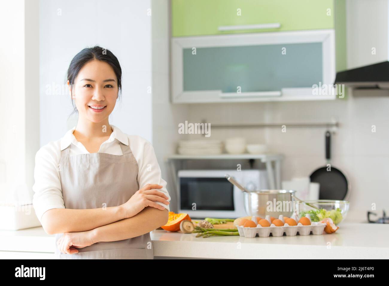 Jeune femme au foyer ou chef qui prépare des œufs dans une cuisine familiale - photo de stock Banque D'Images