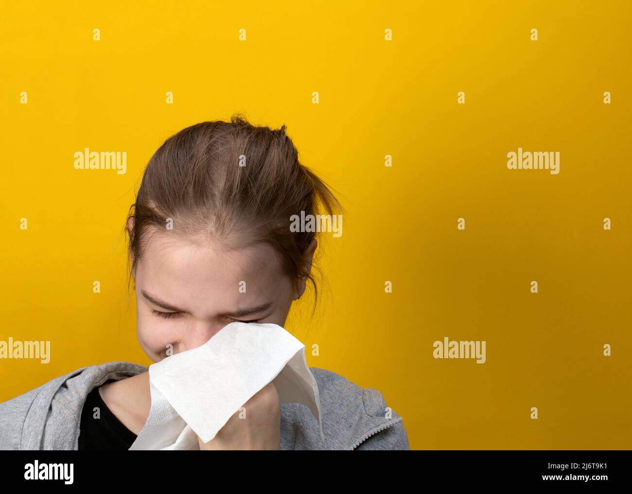 Portrait de la femme pleurant essuyant les larmes avec du papier de soie sur fond jaune. Concept de fille triste ou de femme Banque D'Images