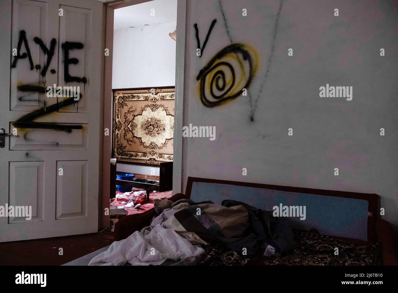 Intérieur d'une maison vandalisée par l'armée russe avec 'Z', 'V' symboles militaires russes et 'A.E.E.E.E.E.E.' qui est l'acronyme d'une organisation informelle de criminels russes sont pulvérisés sur le mur et la porte. Makariv est une ville de Bucha Raion, l'oblast de Kiev, située à 60 kilomètres à l'ouest de la capitale de l'Ukraine. Depuis plus d'un mois sous occupation russe, Makariv n'a pas de ligne d'électricité, d'eau, de gaz ou de télécommunication. Les attaques russes ont détruit quarante pour cent de la zone et de nombreux massacres sont enregistrés. En outre, les troupes russes ont détruit des infrastructures et extrait une certaine territorialité Banque D'Images