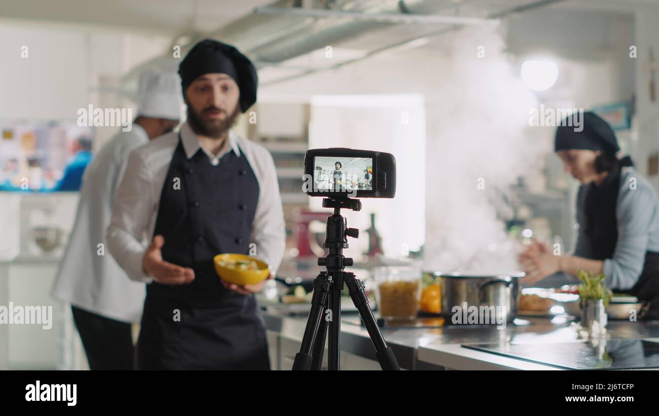 Vidéo professionnelle d'enregistrement de caméra de spectacle de cuisine  dans la cuisine du restaurant, les gens travaillant chez les chefs  préparant un plat gastronomique avec des ustensiles. Filmer la recette  culinaire, expliquer