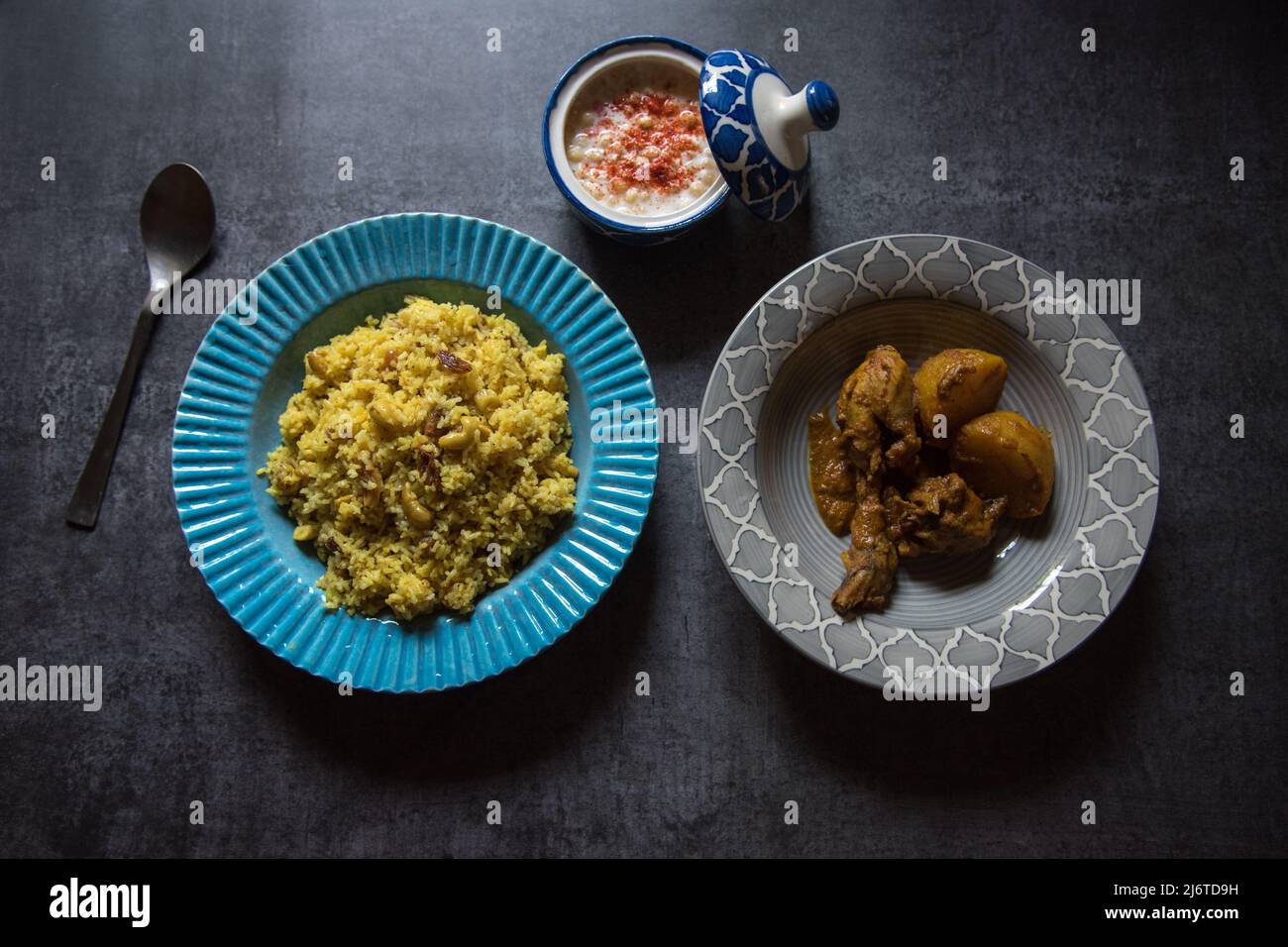 Repas indien à base de riz basmati et de curry de poulet servi dans un bol sur fond sombre. Vue de dessus, mise au point sélective. Banque D'Images